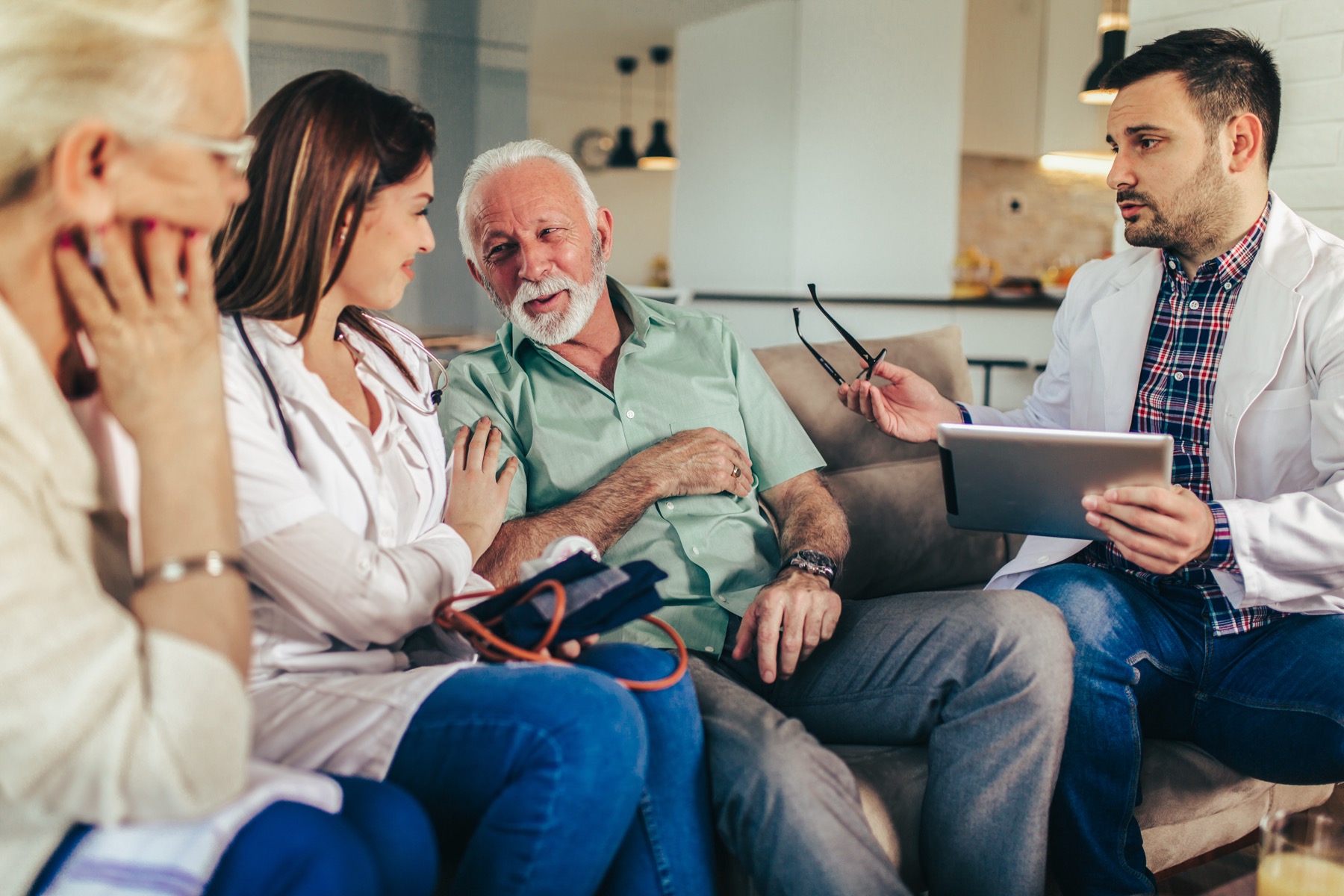 An Alleviate physician and nurse reviewing a plan of care with a patient and family member at home